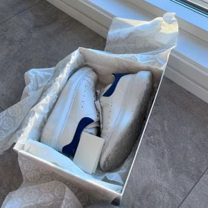 Vita sneakers från Alexander McQueen - Säljer mina fina McQueen skor i storlek 37,5 som inte längre kommer till användning.   Köpta för 5 149kr. Säljer för 1 200kr.   Säljer de så pass billigt för de är lite smutsiga, tror dock att om man har rätt verktyg så försvinner de mesta fläckarna.   Tveka inte att skriva för fler bilder eller om du har några frågor🩷