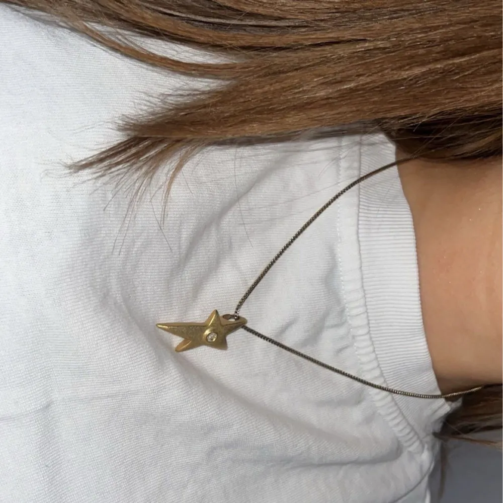 Elegant halsband med ett stjärnformat hänge i guld. Hänget har en liten kristal i mitten som är så himla fin . Perfekt för att lysa upp vilken outfit som helst. Jag har knappast använt halsbandet och är i nyskick. Asusteet.