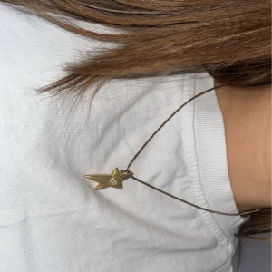 Guldhalsband med stjärnhänge - Elegant halsband med ett stjärnformat hänge i guld. Hänget har en liten kristal i mitten som är så himla fin . Perfekt för att lysa upp vilken outfit som helst. Jag har knappast använt halsbandet och är i nyskick