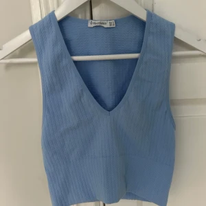 Blå ribbad topp från Stradivarius - Säljer en snygg blå ribbad topp från Stradivarius. Toppen har en v-ringad design. Säljer pågrund av att jag inte längre använder den. Pris kan diskuteras vid snabb affär😊