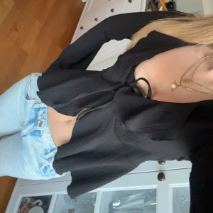 Svart blus med knyt och volangdetaljer - så fin blus utan defekter!! 