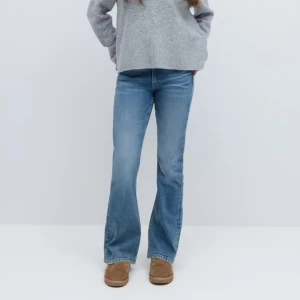 Blå bootcut jeans - Snygga blå bootcut jeans från Gina Tricot Young . Aldrig använda och prislappen är kvar. Jeansen har en lätt tvättad look och stängs med dragkedja och två knappar. Perfekta för en avslappnad stil.