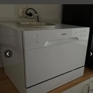 Vit bänkdiskmaskin från Matsui - Säljer en kompakt vit bänkdiskmaskin från Matsui. Perfekt för mindre kök eller lägenheter. Diskmaskinen har en enkel och stilren design med tydliga knappar för programval och start. Insidan har plats för tallrikar, glas och bestick. Perfekt för dig som vill spara tid och energi i vardagen.