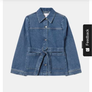 Blå jeansjacka med bälte - (Blandning av trenchcoat och jeans jacka)Snygg blå jeansjacka med knappar och bälte i midjan. Jackan har långa ärmar och stora fickor framtill. Perfekt för en avslappnad stil. Ord pris 800, säljer för 539!