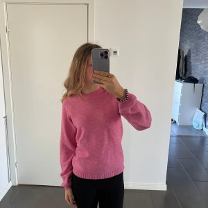 Rosa stickad tröja från Only  - Säljer en snygg rosa stickad tröja från Only. Tröjan har en klassisk rund hals och långa ärmar med ribbade muddar. Perfekt för att hålla sig varm och stilren under kyligare dagar. Passar bra till både jeans och kjol.