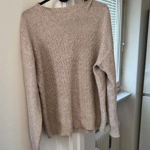 Beige stickad tröja från SHEIN - Säljer en mysig beige stickad tröja från SHEIN med ett diskret mönster. Tröjan har långa ärmar och ribbade kanter vid hals, ärmslut och nederkant. Perfekt för kyliga dagar!