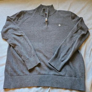 Grå tröja med dragkedja från Morris - Säljer en stilren grå tröja från Morris med dragkedja och broderad logga på bröstet. Tröjan har långa ärmar och ribbade muddar, perfekt för en klassisk look. Säljer den här tröjan pga att den är för liten för mig. Kan gå ner lite i pris om det är en snabb affär. Originalpris är 1600.