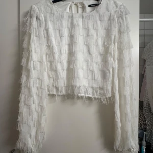 Vit fransig topp och kjol från Gina Tricot - Snyggt vit set från Gina. Oanvänt då de är fel storlek. Kjolen har prislappen kvar, men inte tröjan dock är inte tröjan heller använd. Storlek på kjol och tröja: S