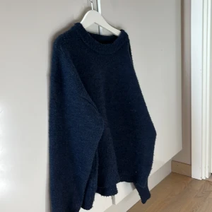 Mörkblå stickad tröja från Gina young  - Säljer en mysig mörkblå stickad tröja från Gina young. Perfekt för kyliga dagar med sin mjuka och varma känsla. Tröjan har en klassisk rund hals och långa ärmar. Passar perfekt till både jeans och kjol.