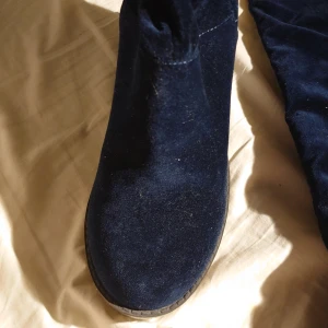 Mörkblå mockastövlar med klack - Snygga mörkblå stövlar i mocka med hög klack och grov sula. Det står storlek 38 på botten, men det är min storlek och jag fick inte alls in foten. Skulle säga att den är kanske 36-37, väldigt liten innuti. Köpte dem begagnade men de är så gott som nya.