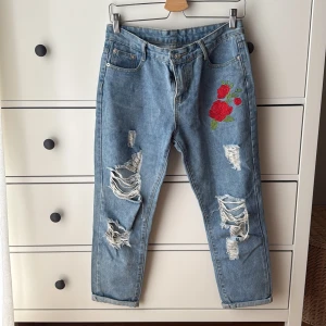 Ljusblå jeans med broderad ros och slitningar från YA SHI - Used but in good condition 