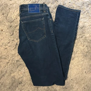 Jacob Cohen jeans 33 - Snygga blå jeans från Jacob Cohën med klassisk femficksdesign och kontrastsömmar. Byxorna har normal passform och stängs med knappar. Perfekta för dig som gillar stilrena och tidlösa jeans. Storlek 33 men passar mer 32 