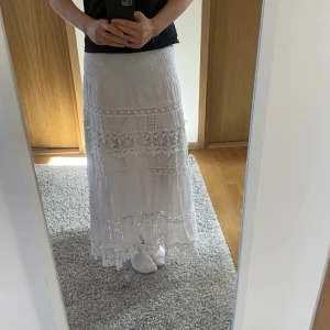 vit kjol - Supergullig vit långkjol med spetsdetaljer. Säljer då den tyvärr inte kommit till användning då den är lite kort på mig som är 168💞