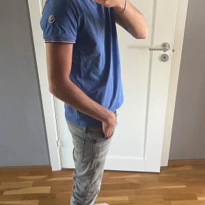 Blå t-shirt från Moncler - Säljer en blå t-shirt från Moncler med slimfit passform. Den är i näst intill nyskick och sparsamt använd köpt på NK i Göteborg förra året för priset 3499