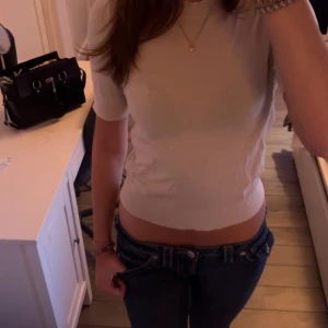 Beige croppad ribbad topp - Säljer en beige croppad topp med ribbad struktur och korta ärmar. Toppen har en tight passform och rund halsringning. Perfekt att matcha med jeans eller kjol.