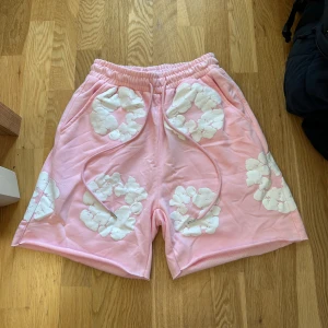 Rosa shorts från Denim Tears - Rosa shorts från denim tears, dessa shorts är i nytt skick alltså de har aldrig används som man kan se på taggen, storlek S. Pris kan diskuteras