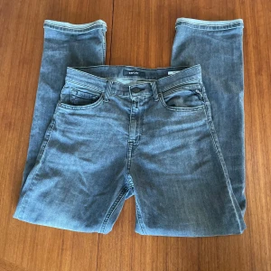 Mörkgrå Replay jeans - Säljer dessa mörkgrå Replay jeans i modellen Thad. Jeansen är 9/10 skick. De är perfekta för en stilren outfit och går att matcha till nästan allt. Storleken är 158cm vilket motsvarar ungefär W27 L29.