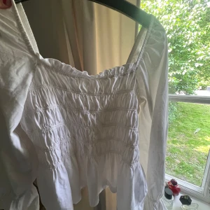 Vit blus med puffärm - Supersöt vit blus med puffärmar. Toppen har en fyrkantig ringning. Så fin till sommaren men kommer inte till användning 