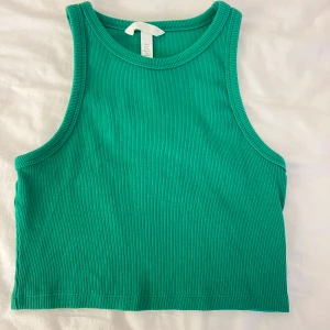 Grön ribbad croppad linnetopp H&M - Snygg grön croppad linnetopp från H&M i ribbad bomull. Säljer i storlek S men passar även en Xs. Pris kan alltid diskuteras 🫶🏼