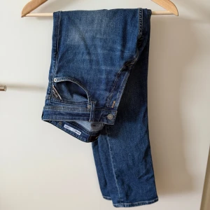 Replay blå jeansbyxor herr - Snygga blå jeansbyxor från Replay med klassisk femficksdesign och läderpatch bak. Jeansen har raka ben och normal passform, tillverkade i slitstarkt jeanstyg. Perfekta för dig som gillar en tidlös och avslappnad look.