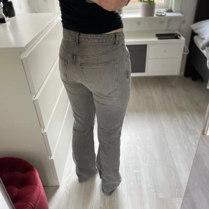 Grå bootcut jeans - Säljer ett par gråa jeans med bootcut-modell från GinaTricot. Jeansen har klassiska fickor både fram och bak samt bälteshällor. Materialet är denim och färgen är en snygg, ljusgrå tvätt som passar till det mesta. Använda fåtal gånger och superfint skick!! Storlek M/40 