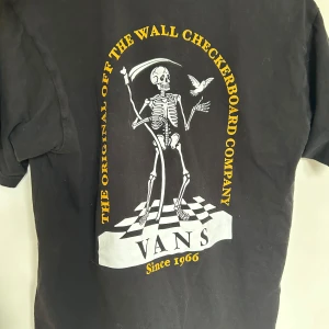 Svart Vans t-shirt med skelettmotiv - Svart t-shirt från Vans i klassisk passform, tillverkad i bomull. Stor tryck på ryggen. Köptes för ett tag sedan men har bara hängt i garderoben