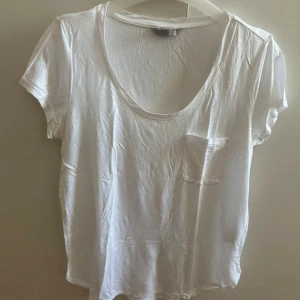 Vit oversized t-shirt med ficka - Enkel vit oversized t-shirt med rund halsringning och liten bröstficka. T-shirten har korta ärmar och är perfekt för en clean och avslappnad stil