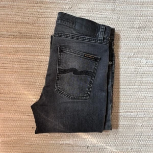 Nudie jeans grå/svart - Hej! Säljer nu mina trendiga nudie jeans då de blivit för små för mig. Det tar i att behöva sälja dessa då det är riktigt sköna och har varit en av mina favorit jeans. Jeansen är slim fit passform (modell: Lean Dean) och sitter riktigt snyggt. Kontakta vid frågor!☺️
