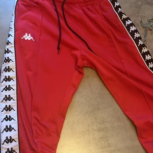 Kappa byxor röda  - Ett par kappa byxor som är röda , bra skick, knappar på sidorna som du kan knäppa upp 