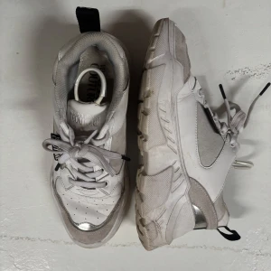 Vita sneakers  - Chunky vita sneakers, Skorna har tydlig logga på sidan, snörning och en rejäl sula som ger en cool streetkänsla. Perfekta för dig som vill sticka ut med stil.
