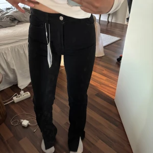 Svarta high waist jeans från Bershka - Säljer ett par svarta high waist jeans från Bershka i klassisk femficksmodell. Jeansen har raka ben och sitter snyggt över höften. Materialet är denim med lite stretch för extra komfort. 