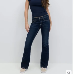 Mörkblå bootcut jeans - Snygga mörkblå jeans i en bootcut-modell och markerade vita sömmar. Dem är låg midjade och jeansen  och är rätt så stretchiga.