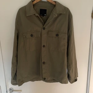 Grön Overshirt - Snygg grön overshirt från lager 157. Storleken e L men skulle passa M också. Utan defekter eller tecken på användning. Resellar för att den inte passade i storleken då jag oftast har L eller XL