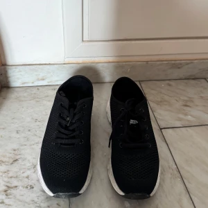 Svarta sneakers med vit sula - Svarta sneakers med vita, chunky sulor. Skorna har klassisk snörning och rund tå. Perfekta för dig som gillar sportig och enkel stil. Lätta och bekväma för vardagsbruk. Skorna är knappt använda och ser ut att vara nya.