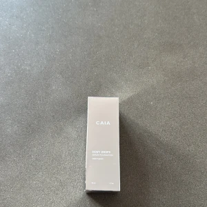 CAIA Dewy Drops Serum Foundation 10C - CAIA Dewy Drops Serum Foundation i nyansen 10C. Kommer i en frostad glasflaska med silvrig pump. Innehåller     30 ml och är berikad med vitamin E och glycerin för återfuktning och lyster. Ger en naturlig, fräsch finish och är lätt att applicera. Helt ny och oanvänd. 