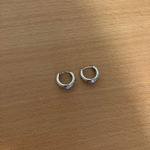 Silvriga chunky hoops örhängen - Säljer ett par chunky hoops i silverfärgad metall. De är runda och har en enkel, stilren design med smidig klickstängning. 