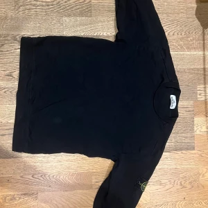 Svart sweatshirt från Stone Island - Säljer en svart sweatshirt från Stone Island med den klassiska loggan på vänster ärm. 