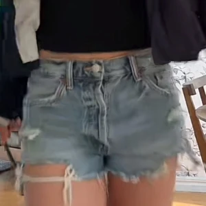 Jeansshorts med fransar - Säljer ett par blå jeansshorts med slitna detaljer och fransig kant, har typ aldrig använt. Bläddra för fler bilder!! 