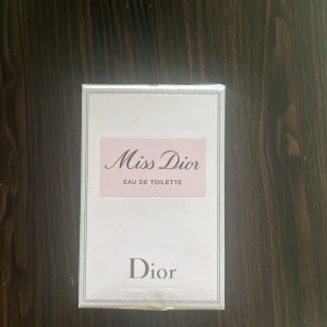 Miss Dior Eau de Toilette 100ml - Miss Dior Eau de Toilette från Dior i en elegant, ljusrosa och vit kartong med silverdetaljer. Flaskan rymmer 100 ml och är en klassisk doft med fräsch och feminin känsla. Perfekt för dig som gillar exklusiva och tidlösa parfymer. O öppnad