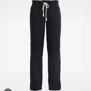 Svarta linnebyxor med snörning - Snygga svarta linnebyxor med rak passform och vit snörning i midjan. Byxorna har resår i midjan och två sidofickor. Perfekta för en avslappnad och stilren look.