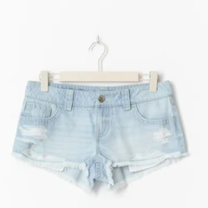 Ljusblå låg midjade jeansshorts med fransar  - Snygga ljusblå jeansshorts med fransig kant och slitna detaljer framtill. Klassisk femficksmodell med knapp och dragkedja. Perfekta för varma dagar och enkel att matcha med olika toppar.