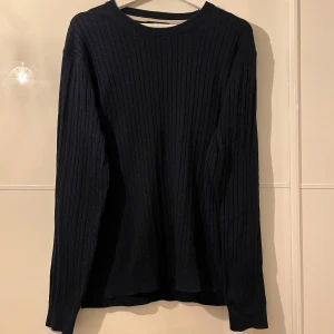 Mörkblå stickad tröja - Mörkblå stickad tröja med en snyggt mönster. Inga defekter, använd fåtal gånger, mycket bra skick. Går perfekt ihop med en pike/skjorta under eller bara en t-shirt! Hör av er vid funderingar 🙌