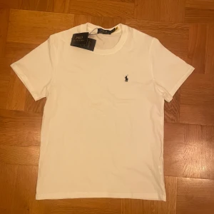 Vit t-shirt från Polo Ralph Lauren - Helt ny vit T-shirt från polo Ralph lauren fick den ett tag sedan fast vill sälja den nu, den är perfekt nu till sommaren och skön, Den är storlek M men kan passa mindre. priset kan sänkas vid snabb äffar. 