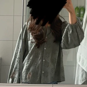 Grön blommig blus - Säljer denna otroligt söta blusen från dobber med broderade blommor. Blusen är i toppenskick då den knappt är använd. Blusen är i storlek L men för mig som brukar ha S sitter den superbra. Köpt för 599 kronor.