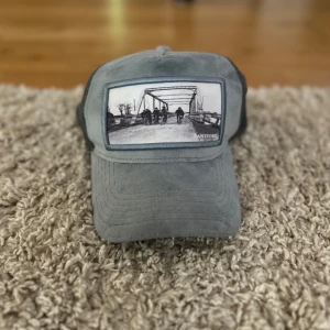 Grå keps från Zantiore - Snygg grå keps med mörkgrå mesh baktill och justerbar. One size så därför passar den till alla.