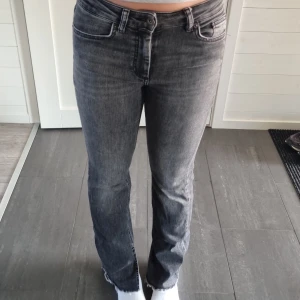 Grå jeansbyxor från ONLY - Säljer ett par grå jeansbyxor från ONLY med klassisk femficksdesign och normal passform. Byxorna har hög midja och utsvängda ben, perfekt för en stilren look. Materialet är mjukt denim och färgen är tvättad grå.