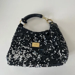 Damväska - Hej, hjälper mamma rensa garderoben. Säljer denna snygga väska i glitter för ett kanonpris. Väskan är i bra skick, först till kvarn!