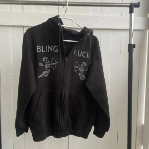 Svart hoodie  - Säljer denna Svarta hoodie från Bling Lucid med dragkedja, skön tröja och bra passform. Den är inte använd jätte mycket och inga spår på att den är använd. Säljes pågrund av att jag vuxit ur den. 