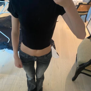 Svart croppad topp med kort ärm - En svart, croppad topp med korta ärmar och djup, rundad rygg, eller så kan man ha den bak och fram så blir den urringad där fram 