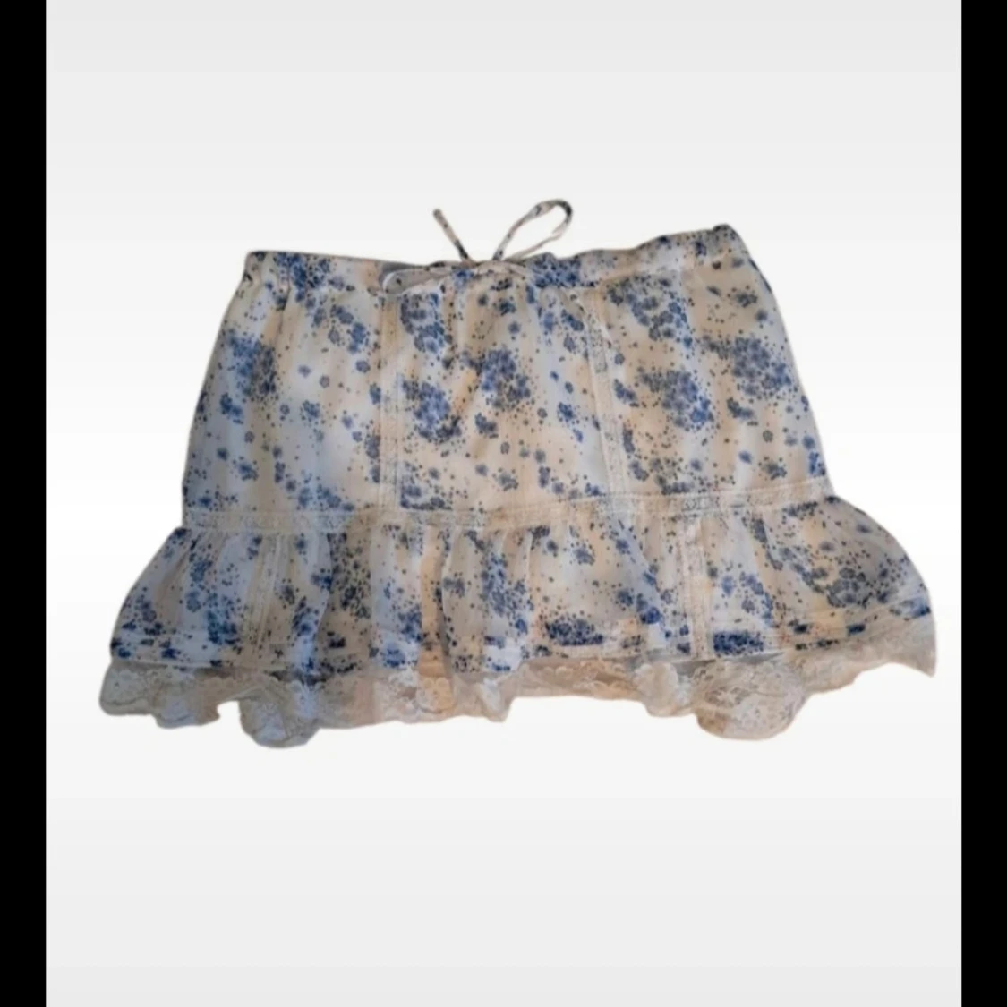 Vit somrig kjol med blå blommor, röda detaljer och spetsdetaljer i storlek M 